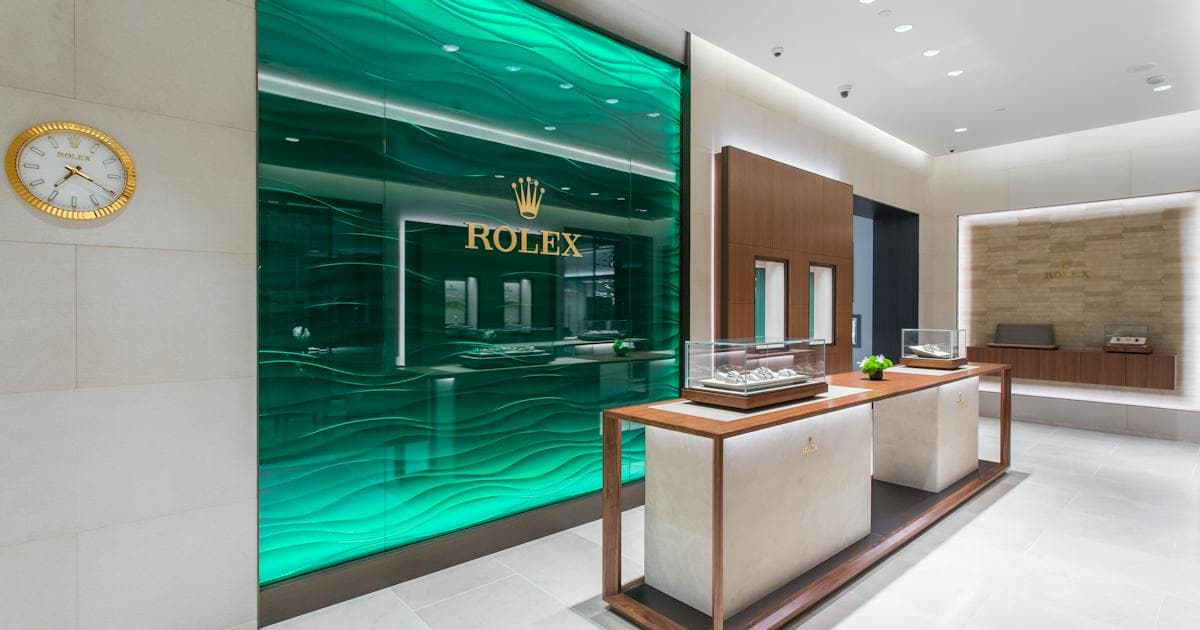 Modern luxury retail interior with green-lit storefront and polished white flooring