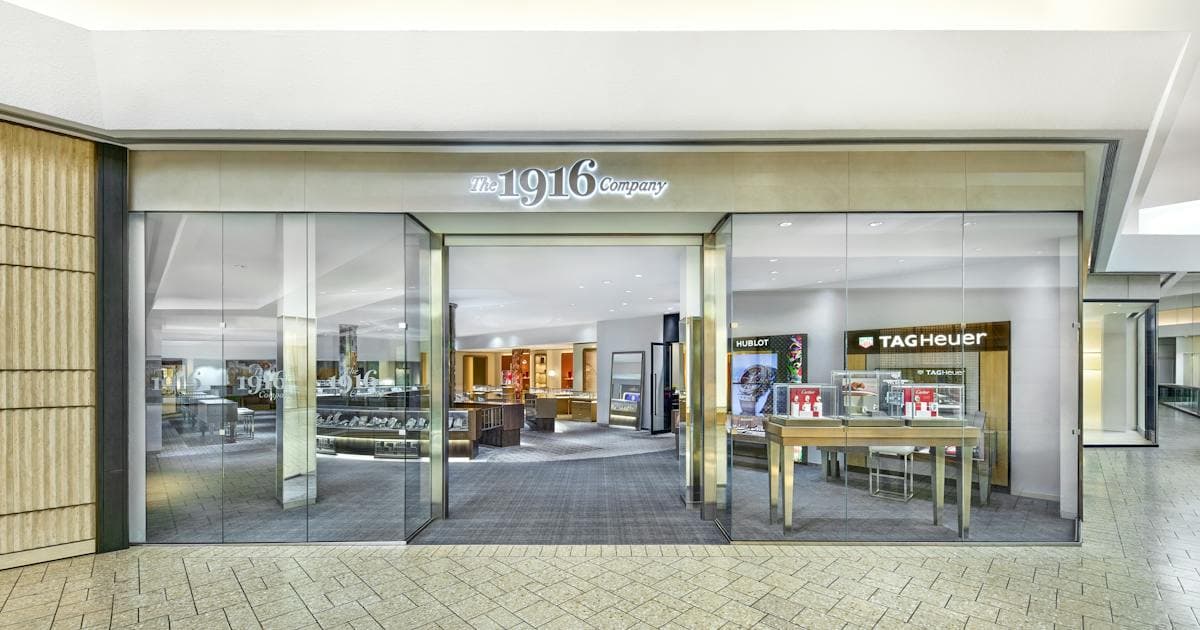Modern storefront of The 1916 Company with glass doors and luxury brand displays